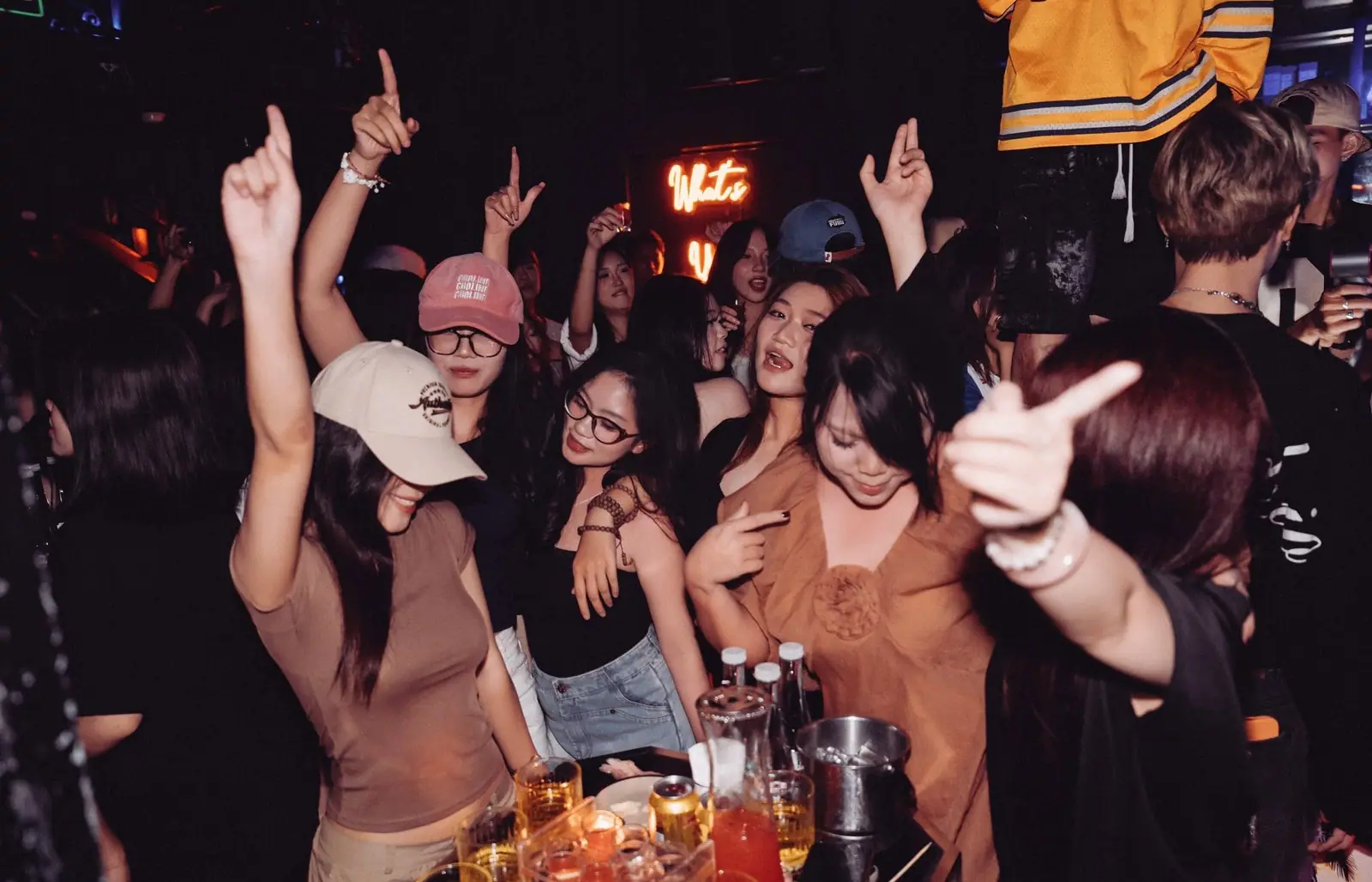Nhóm bạn nữ nhảy và tạo dáng cạnh biển neon viết tay tại Dopamine Hanoi