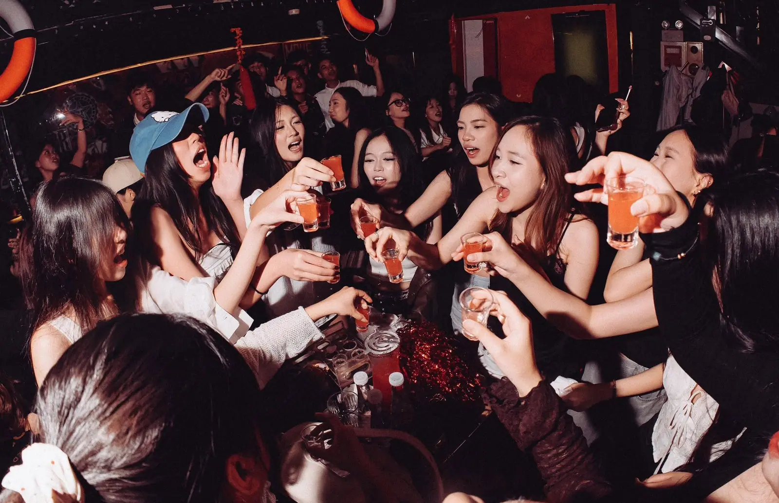 Nhóm bạn nữ cười đùa quanh bàn trong một đêm tiệc tại Dopamine Hanoi
